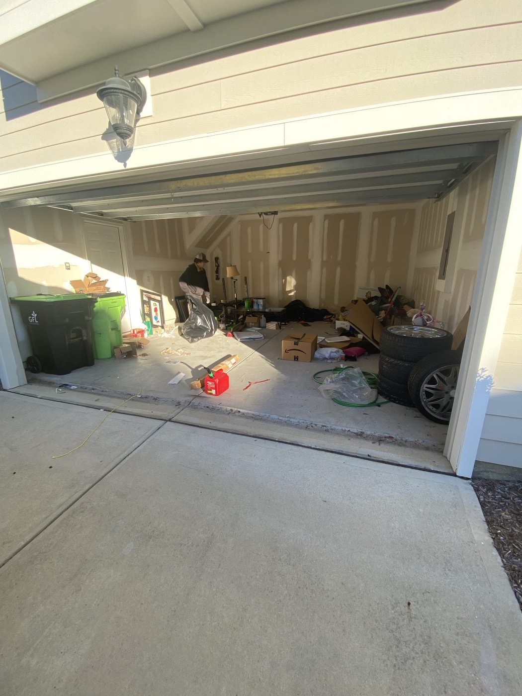 Garage packed with tires, boxes, bags, and junk — before Junk Doctors